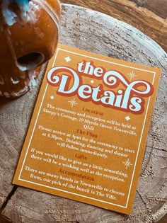 an orange book sitting on top of a wooden table next to a doughnut covered in icing