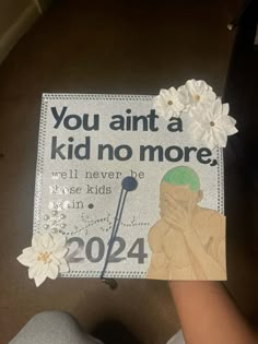 someone is holding up a graduation cap that says you annt a kid no more