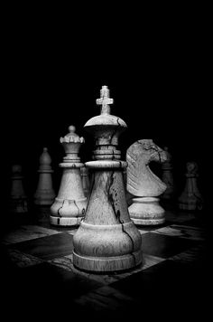 a black and white photo of chess pieces