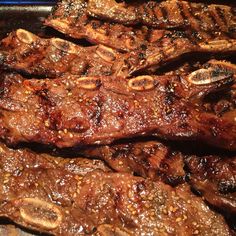 some steaks are cooking on a grill