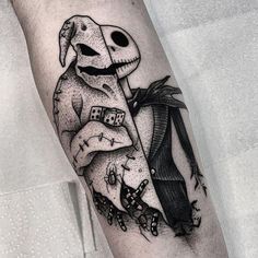 a black and white tattoo with a skeleton holding a card in it's hand