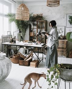 a woman standing in front of a table next to a dog