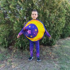 a young boy dressed as a moon and stars holding an inflatable balloon