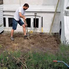 a man is digging in the dirt with a shovel and a garden hose next to him