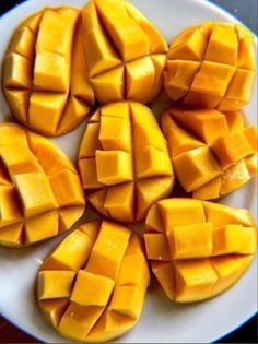 several pieces of mango on a white plate