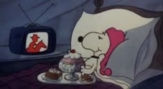 the cartoon dog is eating cake and watching tv