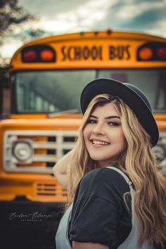 a young woman standing in front of a school bus