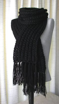 a black scarf is sitting on a mannequin