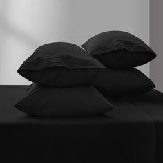 three black pillows are stacked on top of each other