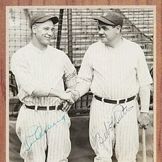 two baseball players standing next to each other in front of a wooden framed sign with writing on it