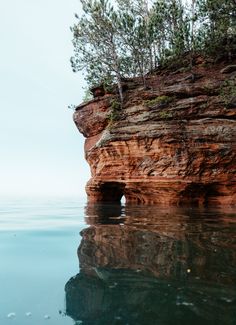 the water is crystal blue and clear with some trees growing out of it's sides