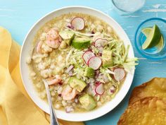 a bowl of soup with shrimp, radishes and avocado garnish