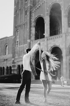 a man and woman dancing in front of an old building