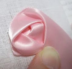 a pink ribbon is being sewn onto a piece of fabric