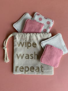 three small pouches with the words wipe, wash, and repeat written on them