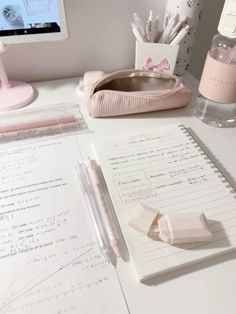 a white desk topped with lots of papers and pens