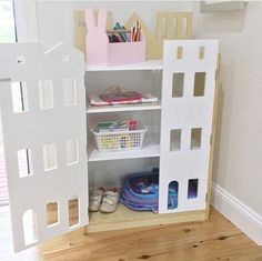 there is a doll house built into the wall with shelves and toys in front of it