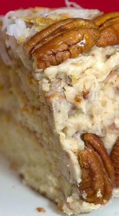 a close up of a piece of cake on a plate with pecans and icing