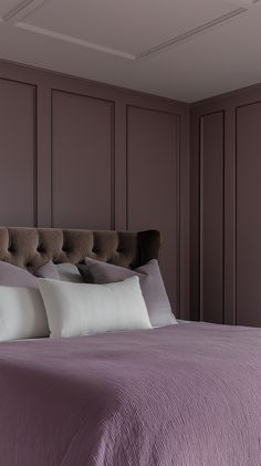 a bed with purple sheets and white pillows