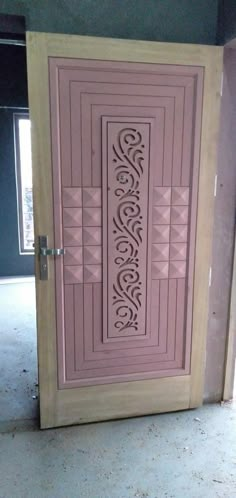 a pink door with an intricate design on the front and side panels, in a room