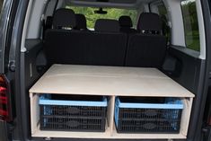 the back end of a van with two crates in it