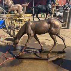 a bronze statue of a horse drinking water