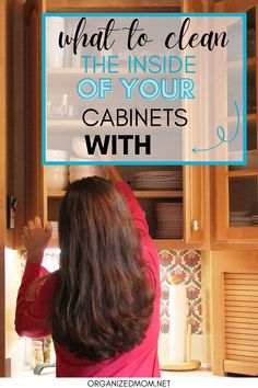 a woman standing in front of a cabinet with the words what to clean the inside of your cabinets with