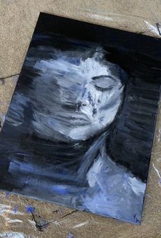 a painting of a woman's face on the ground