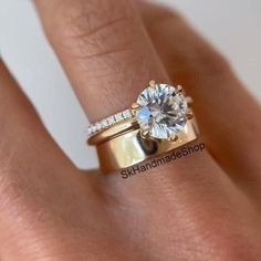 a woman's hand with a diamond ring on top of her finger and the bottom half of her wedding band