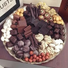 a platter filled with lots of different types of chocolates and candies on top of a table