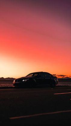 a car is parked on the side of the road at sunset