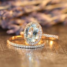 a close up of a ring on a table with purple flowers in the back ground