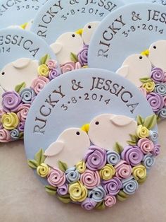 four personalized wedding favors with flowers and birds on them for the bride and groom