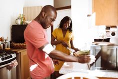 a man and woman are preparing food in the kitchen