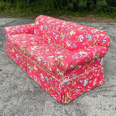 a pink couch sitting in the middle of a parking lot