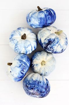 blue and white painted pumpkins sitting on top of each other