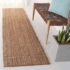 a woven rug on the floor next to a chair