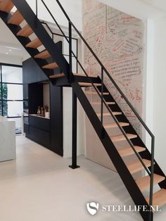 there is a black and white stair case in the room with writing on the wall