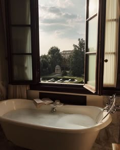 a bath tub sitting under a window in a bathroom