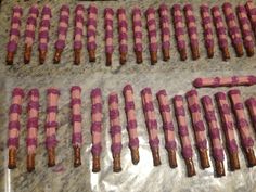 pink and brown candy sticks are lined up on a table