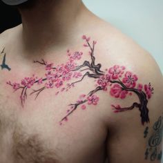 a man's chest with pink flowers and birds on it