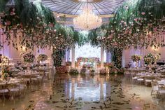 an elaborately decorated banquet hall with chandeliers and floral arrangements on the ceiling