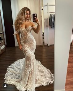 a woman is taking a selfie in her wedding dress while wearing a white gown