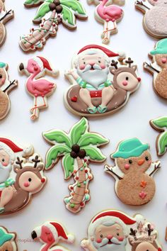 decorated cookies with santa claus and other holiday treats on a white tablecloth covered in icing