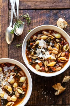 two bowls of pasta soup on a wooden table