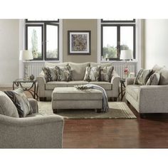 a living room with two couches, a chair and a footstool in it