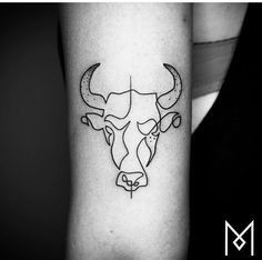 a black and white photo of a bull's head on the arm with an arrow