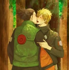 two people are hugging in the woods with their backs to each other and one is wearing a green jacket