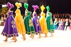 some people are walking down the runway in colorful outfits