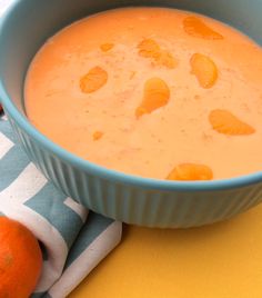 a blue bowl filled with carrots on top of a yellow and white table cloth